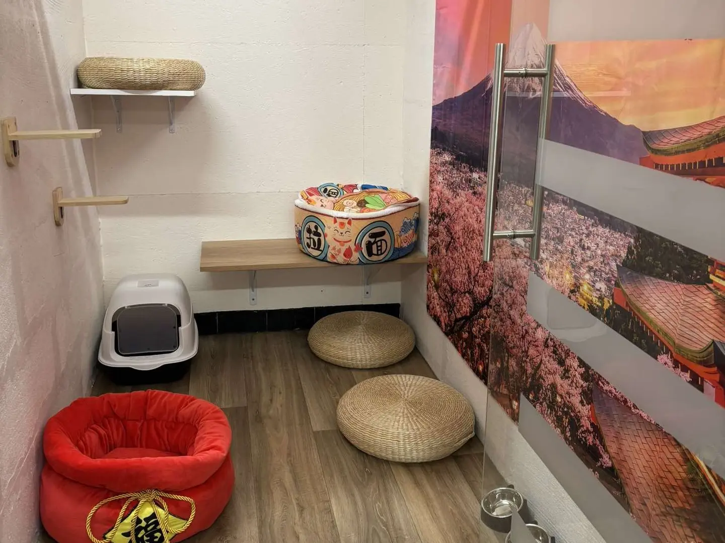 Espace inspiré du Japon avec une fresque de cerisiers en fleurs, un coussin en forme de tambour et un décor zen.