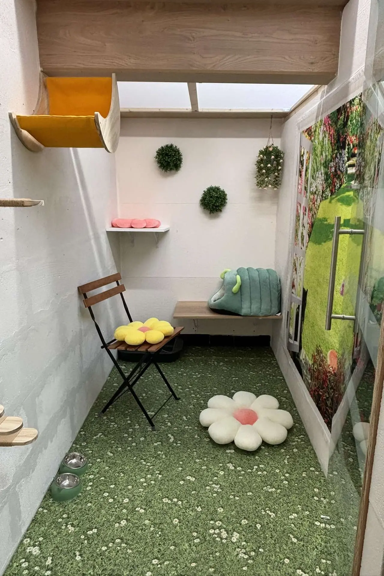 Chambre décorée sur le thème du jardin avec plantes murales, coussins en forme de fleurs et une ambiance naturelle.