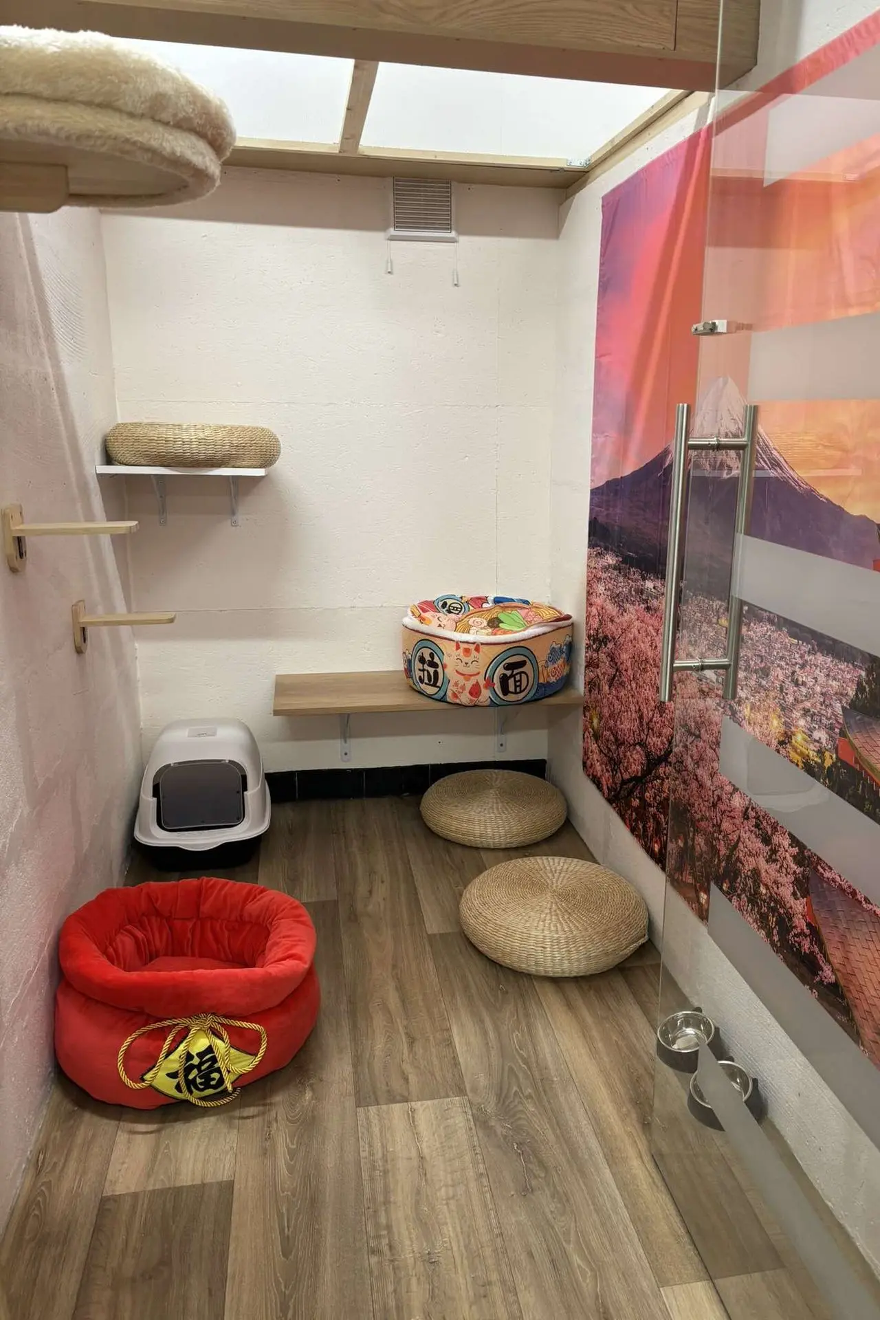 Espace inspiré du Japon avec une fresque de cerisiers en fleurs, un coussin en forme de tambour et un décor zen.